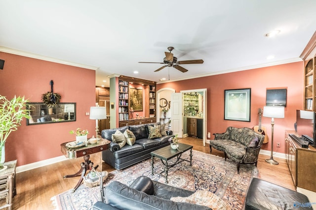 living room with light hardwood / wood-style flooring, ornamental molding, and ceiling fan