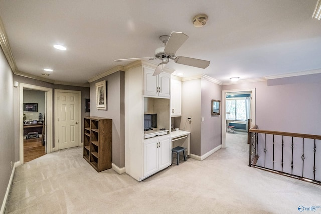 kitchen featuring ceiling fan, ornamental molding, light colored carpet, and white cabinets