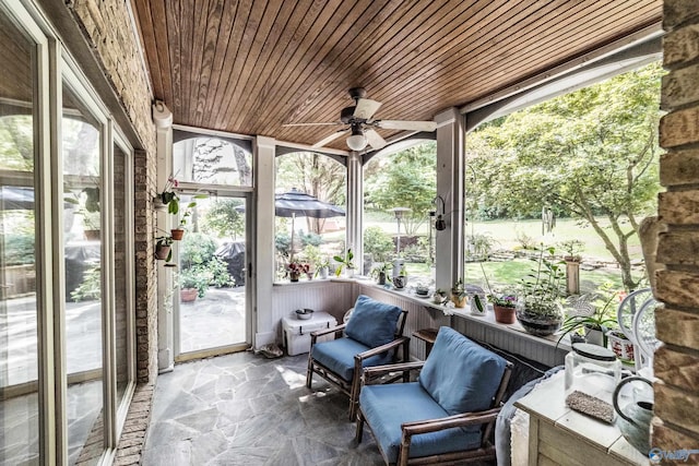 sunroom featuring ceiling fan and wooden ceiling