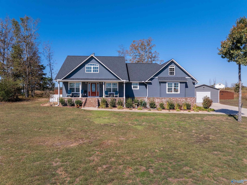 craftsman house with covered porch, an outdoor structure, a front lawn, and a garage