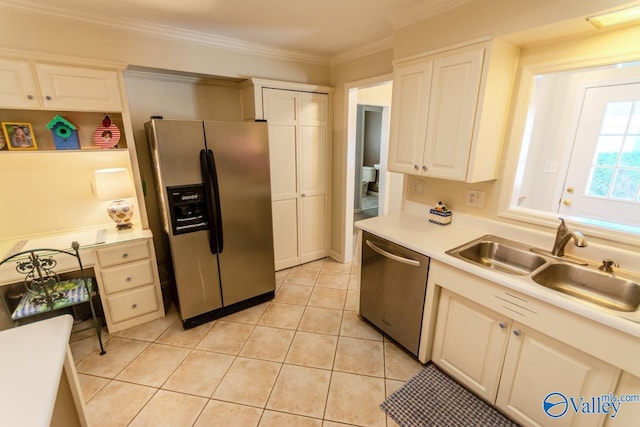 kitchen featuring white cabinets, sink, ornamental molding, light tile patterned floors, and stainless steel appliances