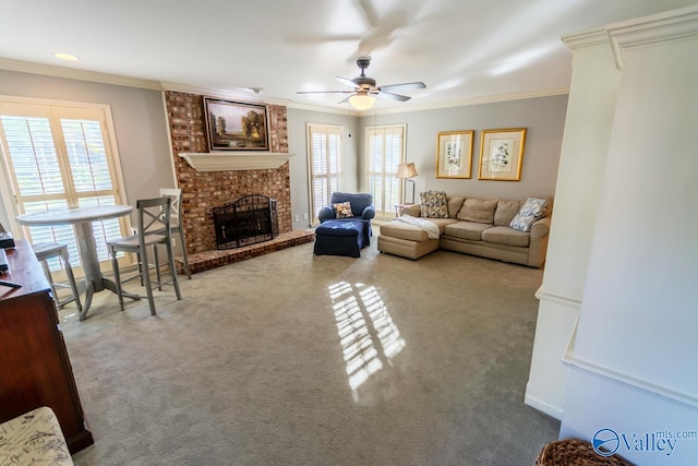 carpeted living room featuring a brick fireplace, plenty of natural light, ornamental molding, and ceiling fan