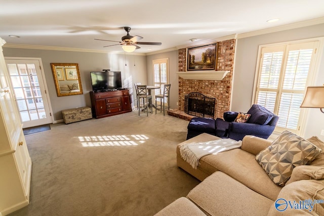 carpeted living room with a brick fireplace, ceiling fan, and ornamental molding