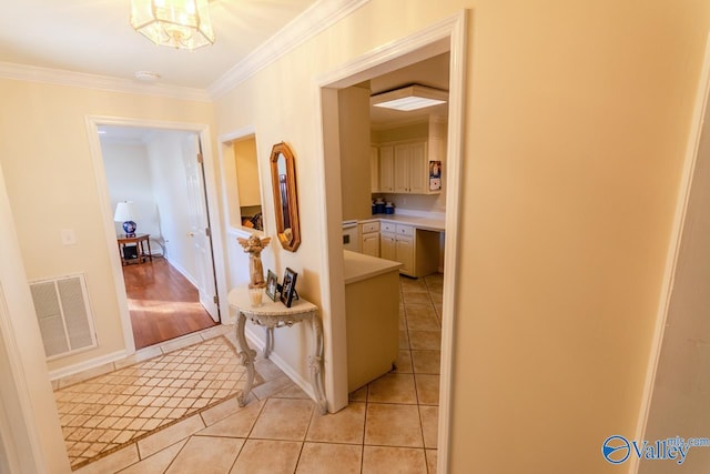 hallway with a notable chandelier, light hardwood / wood-style floors, and ornamental molding