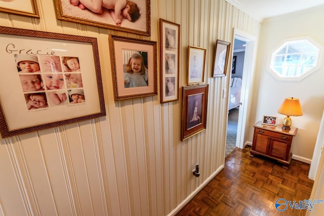 hallway with dark parquet floors and crown molding