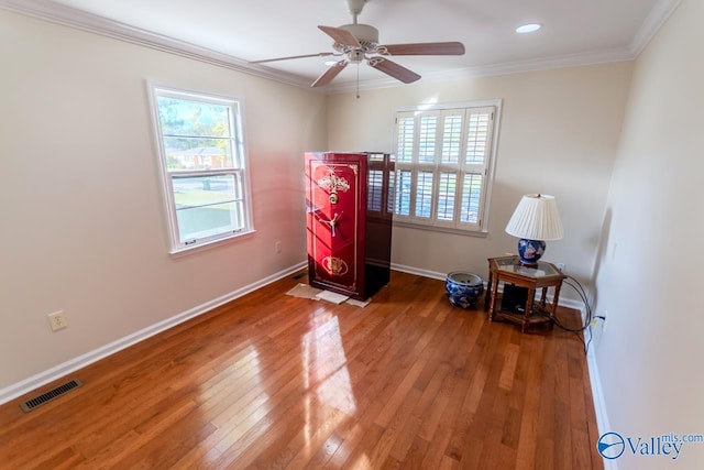 interior space with wood-type flooring, ceiling fan, and crown molding