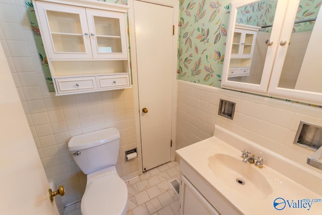 bathroom with tile patterned flooring, vanity, tile walls, and toilet