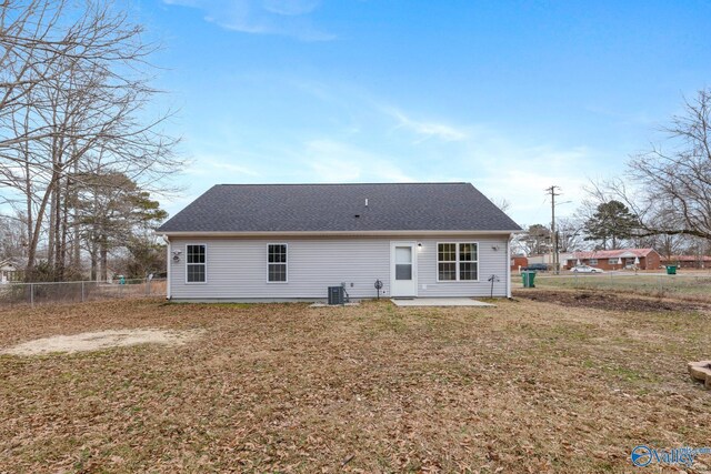 back of house with central AC unit, a lawn, and a patio