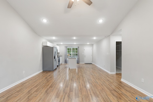 unfurnished living room with light hardwood / wood-style floors, vaulted ceiling, and ceiling fan