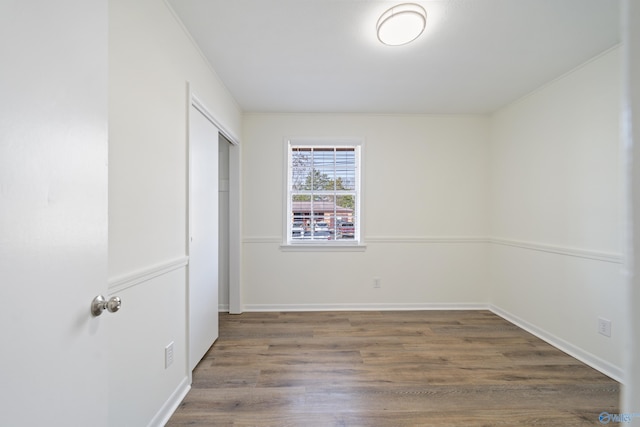 unfurnished bedroom with a closet, wood finished floors, and baseboards