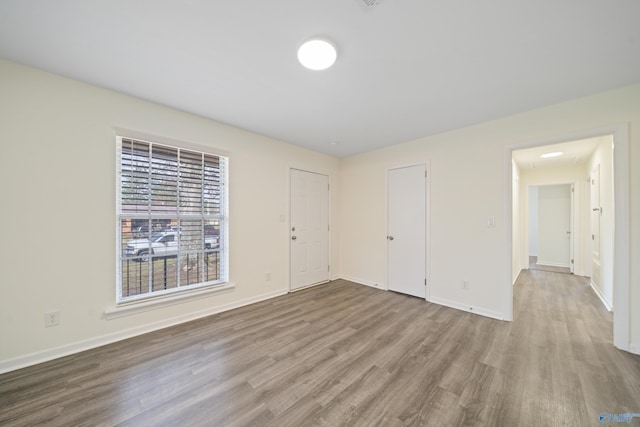 unfurnished room with wood finished floors and baseboards