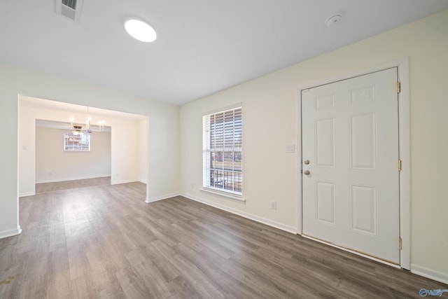 interior space featuring baseboards, visible vents, and wood finished floors