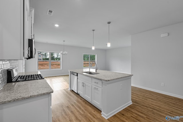 kitchen with a kitchen island with sink, a sink, white cabinets, dishwasher, and pendant lighting