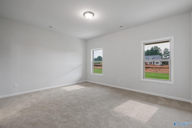 carpeted empty room with visible vents and baseboards