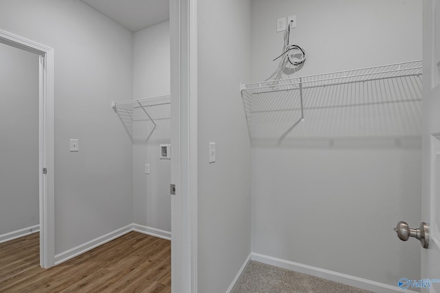 laundry area featuring baseboards and wood finished floors