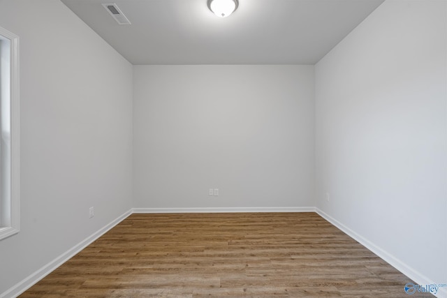 unfurnished room with visible vents, baseboards, and wood finished floors