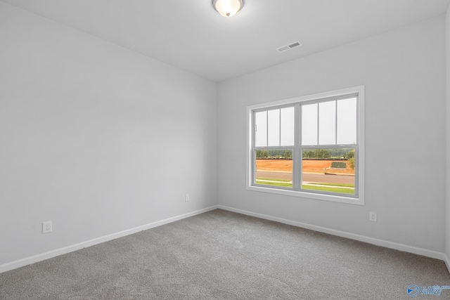 carpeted spare room featuring visible vents and baseboards