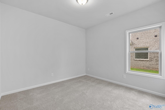 carpeted empty room with visible vents and baseboards