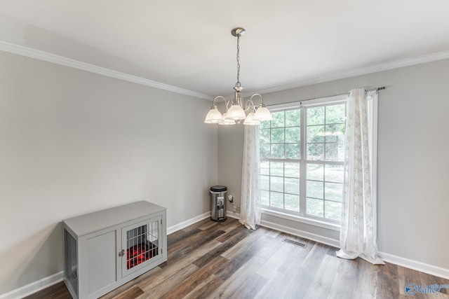 unfurnished dining area featuring ornamental molding, dark wood-type flooring, a wealth of natural light, and an inviting chandelier