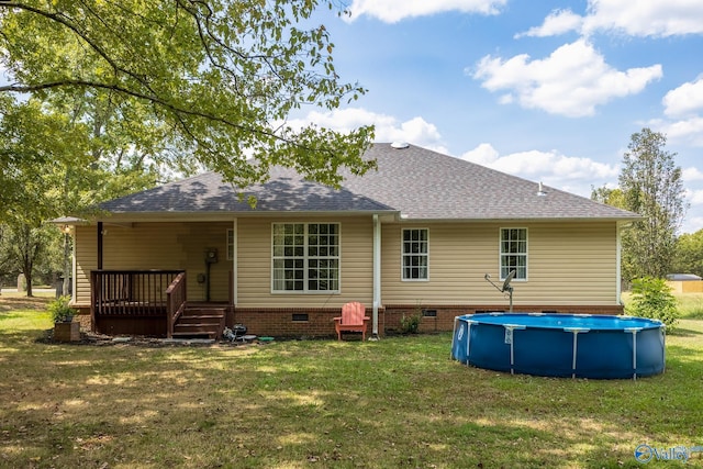 back of house featuring a swimming pool side deck and a lawn