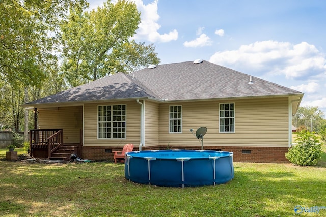 back of house featuring a pool side deck and a yard