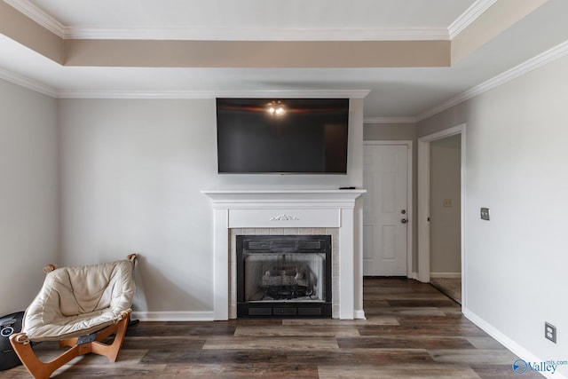 unfurnished living room featuring crown molding, a tray ceiling, a fireplace, and dark hardwood / wood-style floors