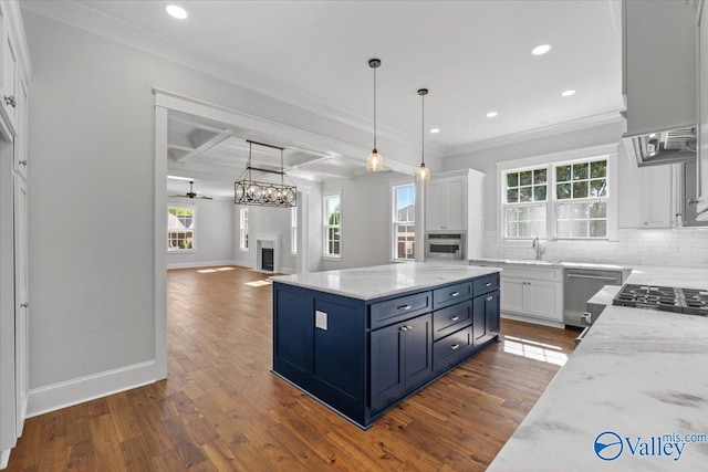 kitchen with appliances with stainless steel finishes, a fireplace, decorative backsplash, and white cabinets