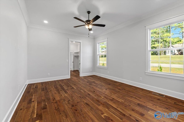 unfurnished room featuring ceiling fan, visible vents, baseboards, ornamental molding, and dark wood-style floors