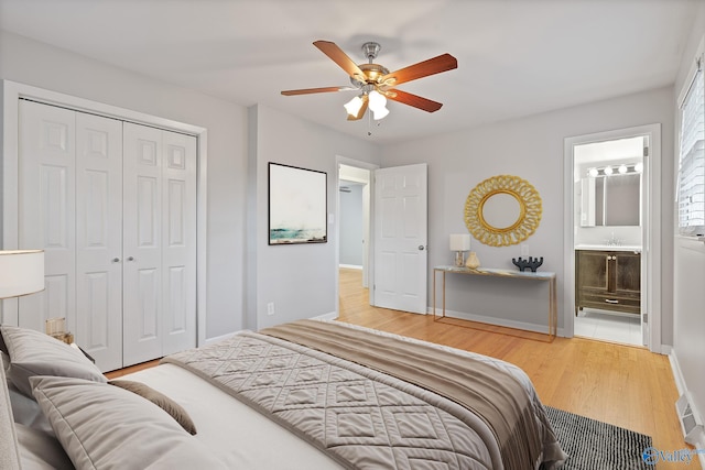 bedroom featuring ensuite bath, ceiling fan, a closet, and hardwood / wood-style flooring