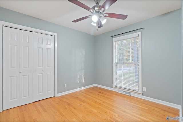 unfurnished bedroom featuring ceiling fan, light hardwood / wood-style floors, and a closet