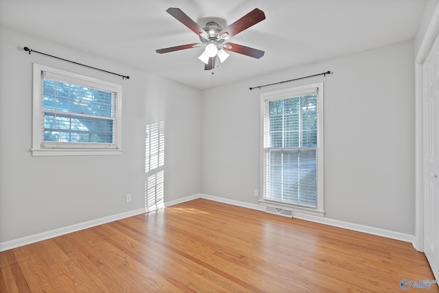 empty room with ceiling fan and light hardwood / wood-style floors