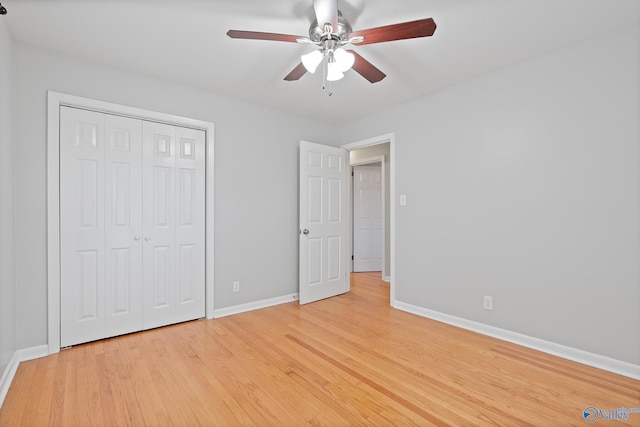 unfurnished bedroom featuring ceiling fan, a closet, and light hardwood / wood-style flooring