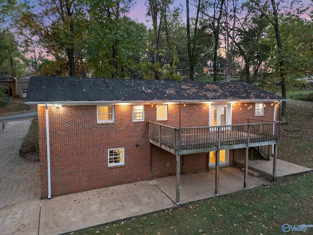 back house at dusk with a deck