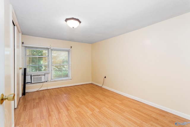 spare room featuring cooling unit and light hardwood / wood-style flooring