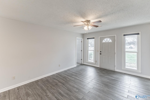 entrance foyer with a textured ceiling, plenty of natural light, ceiling fan, and dark hardwood / wood-style floors