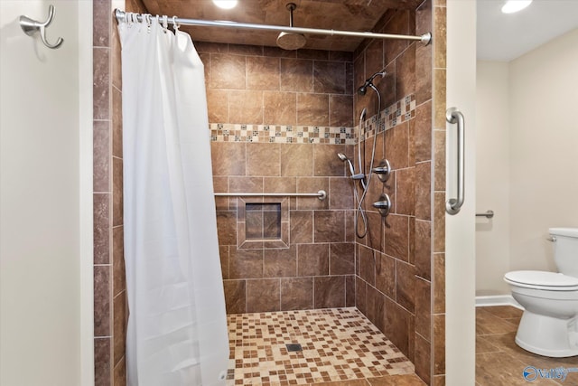 bathroom featuring toilet and a stall shower