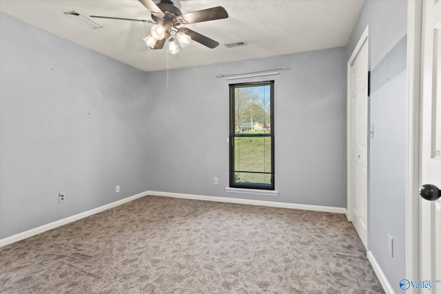 unfurnished bedroom with carpet flooring, a textured ceiling, baseboards, and visible vents
