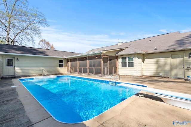 pool with a sunroom and a patio area