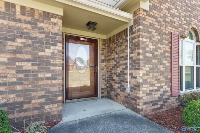 entrance to property featuring brick siding