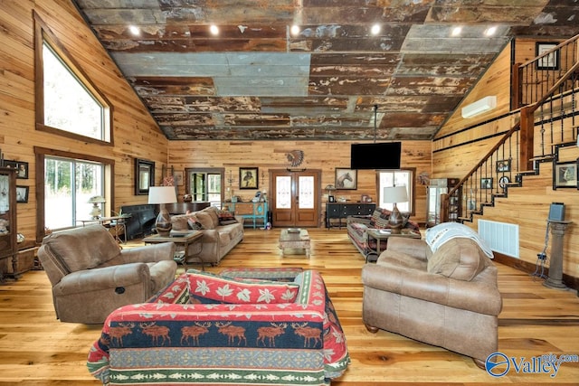 living room featuring french doors, hardwood / wood-style flooring, and wooden walls