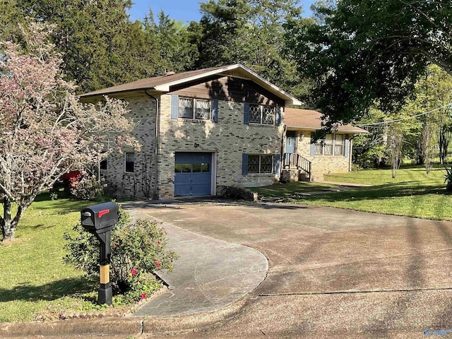 view of front of house featuring a garage, driveway, a front lawn, and brick siding