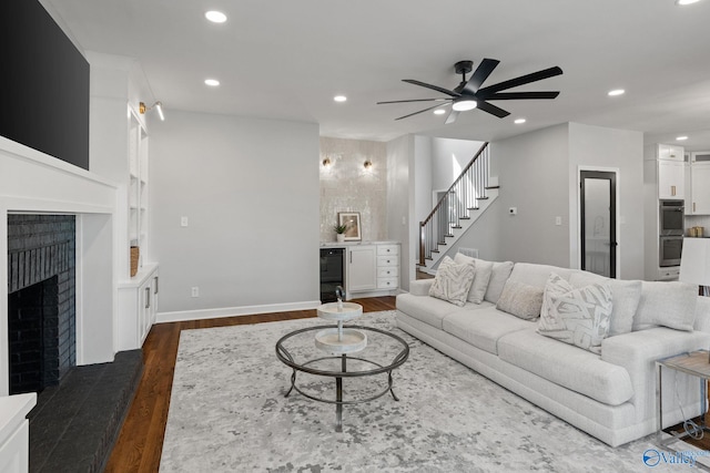 living room with ceiling fan and dark wood-type flooring