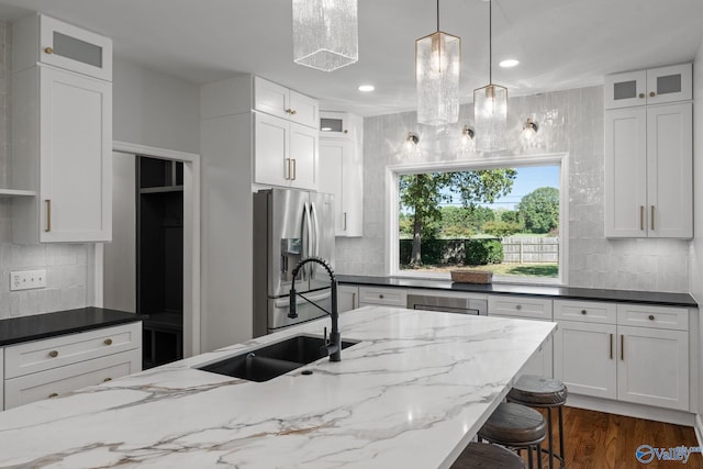 kitchen featuring pendant lighting, decorative backsplash, sink, and white cabinetry