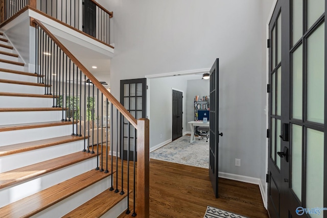 entrance foyer featuring french doors, a towering ceiling, and dark hardwood / wood-style flooring