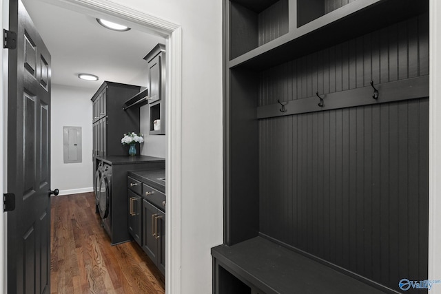 mudroom featuring electric panel, washer and dryer, and dark hardwood / wood-style flooring