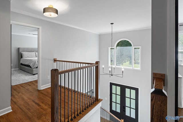 hallway featuring an inviting chandelier, crown molding, and dark hardwood / wood-style flooring