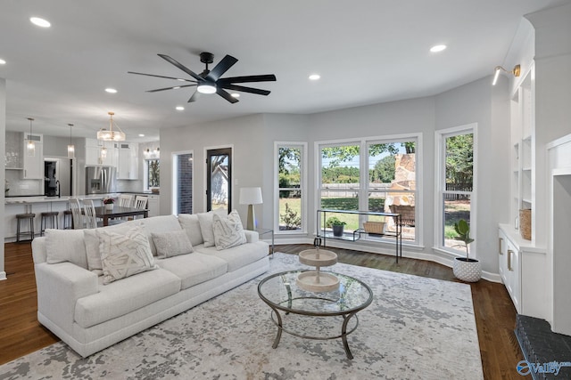 living room with ceiling fan and dark hardwood / wood-style flooring