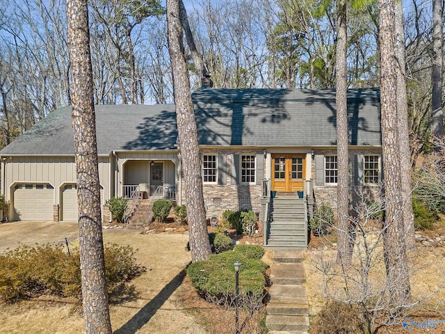 view of front of home featuring a chimney, stairway, an attached garage, covered porch, and brick siding