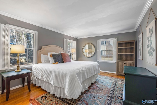 bedroom featuring baseboards, wood finished floors, visible vents, and crown molding