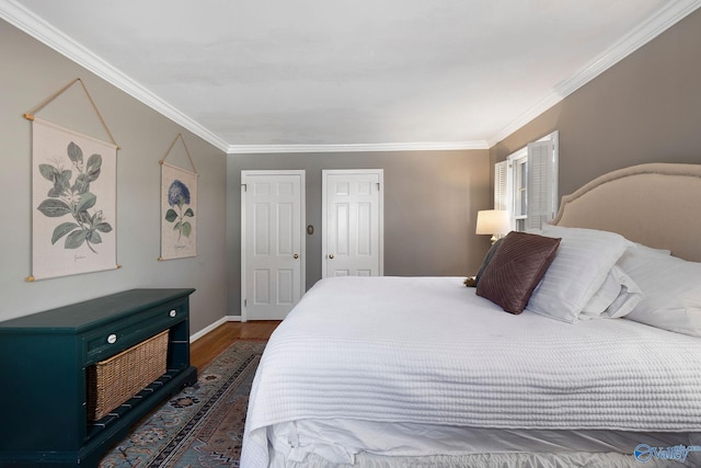 bedroom featuring baseboards, wood finished floors, and crown molding